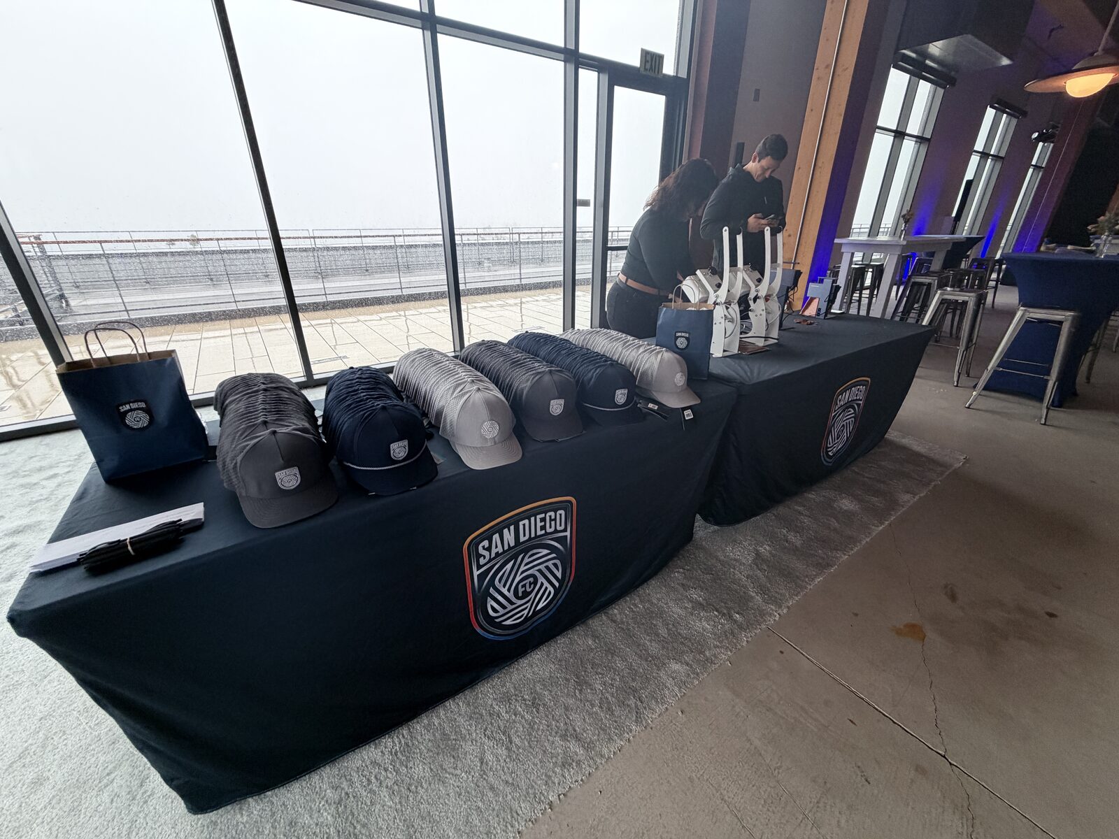 Custom embroidered caps displayed on a branded merch table